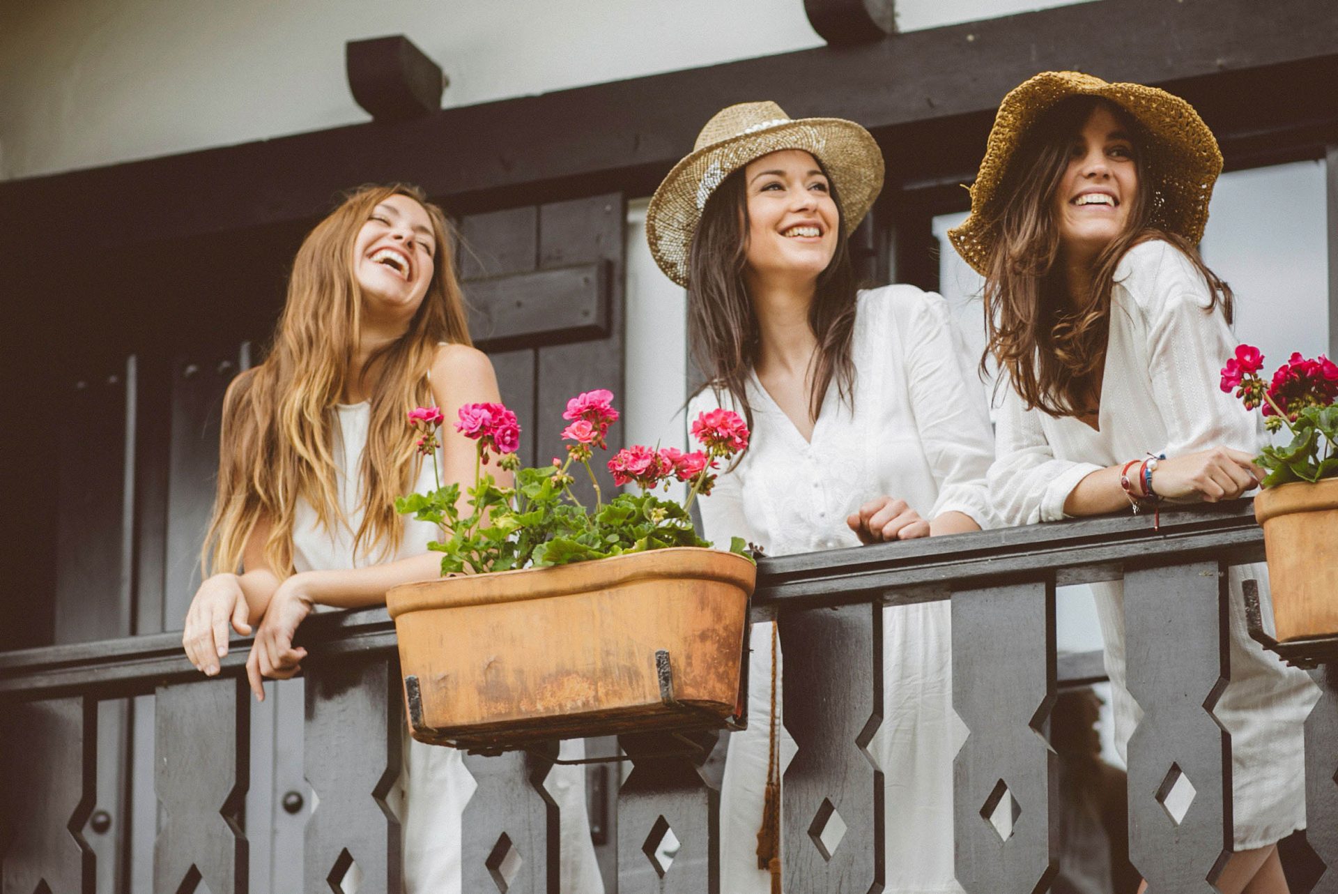 chicas felices con vestido blanco en un balcón